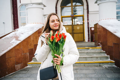 Girl with a bouquet of tulips at the train station, international women's day