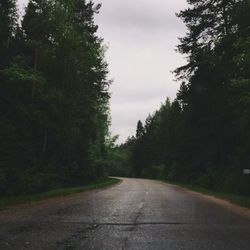 Road amidst trees against sky