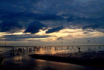 Silhouette pier on beach against sky during sunset