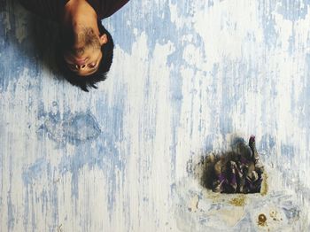 Upside down image of man against weathered wall