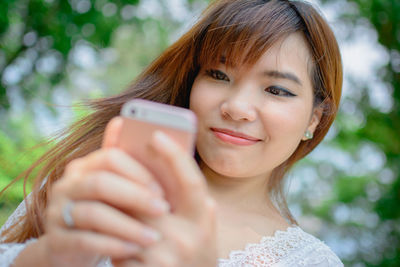 Portrait of young woman using mobile phone outdoors