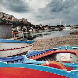 Sailboats moored on beach against sky