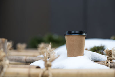 Close-up of coffee in disposable cup on snow