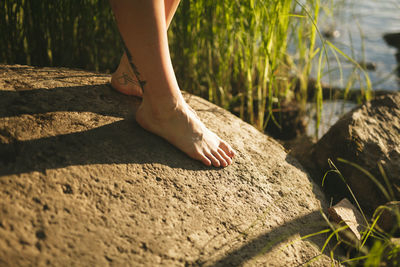 Bare foot on rock at lakeshore barefoot