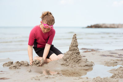 Full length of boy on beach against sky