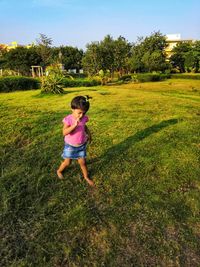  girl eating lollipop while standing at park