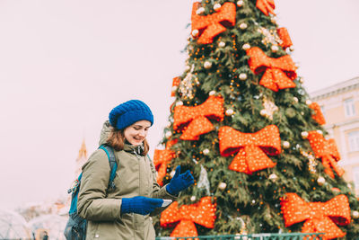 Portrait of smiling friends with christmas tree