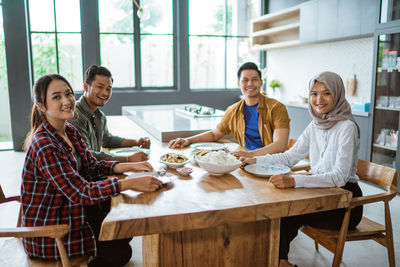 Portrait of smiling family having food at home