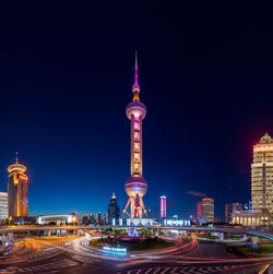 Illuminated buildings in city against sky at night