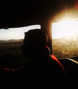 Rear view of silhouette man against illuminated sky at night