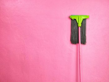 Close-up of colored pencils on pink wall