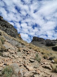 Low angle view of rocky mountains against sky