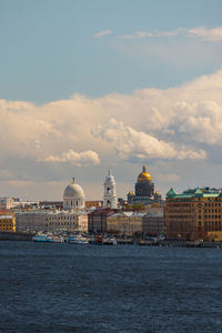 Buildings by sea against sky