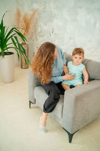Mother with baby on a gray chair. high quality photo