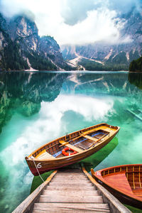 Scenic view of rowboat in calm lake against mountains