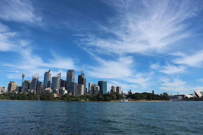 Sea by buildings against sky in city