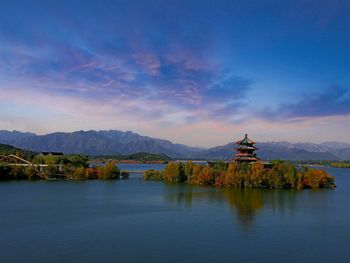 Scenic view of building by mountains against sky