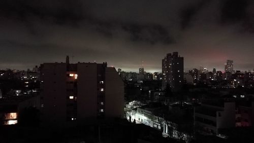 High angle view of illuminated buildings against sky at night