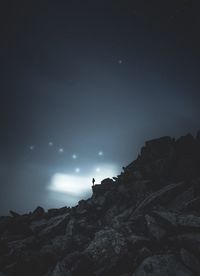 Low angle view of cliff against sky at night