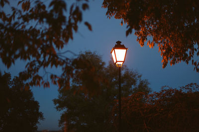 Low angle view of illuminated street light against sky