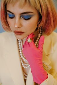 Close-up of beautiful young woman wearing make-up and jewelry