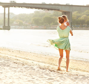 Full length of young woman standing on beach