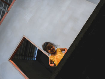 High angle view of boy on orange wall