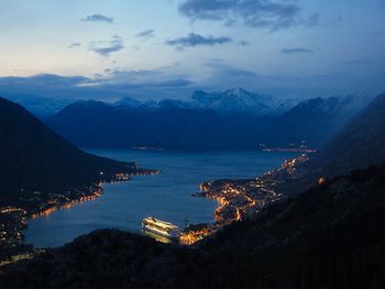 Scenic view of sea and mountains against sky at dusk