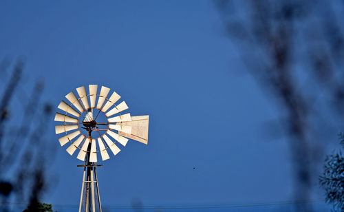 Windmill behind some dried trees at the sunset time in paralimni of cyprus