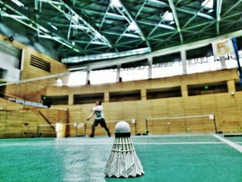 Shuttlecock against man playing badminton at court