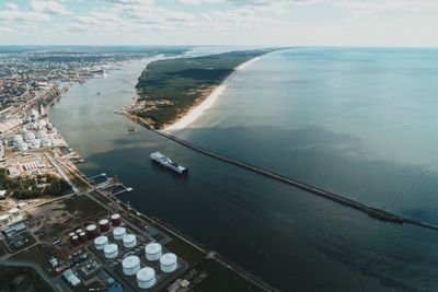 High angle view of cityscape by sea against sky