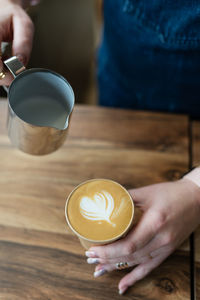 The process of preparing a barista cappuccino with a beautiful pattern in the form of a heart