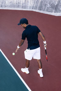 Rear view of man playing tennis