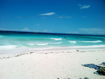 Scenic view of turquoise sea at beach against blue sky