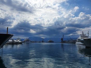 Boats moored at harbor against sky