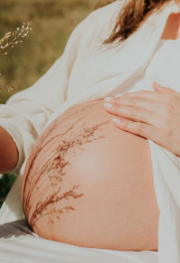 Midsection of woman with henna tattoo