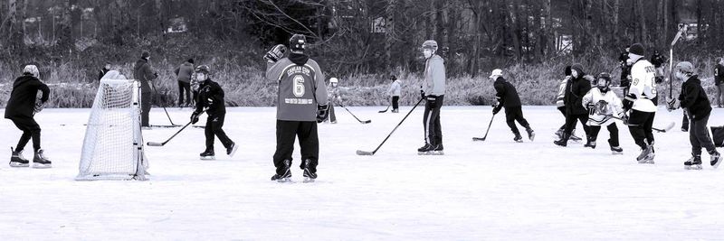 People playing ice hockey on snow covered field