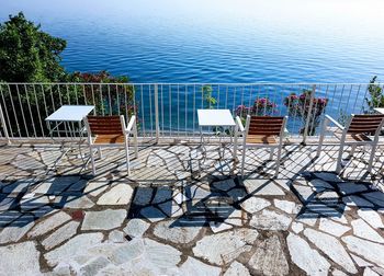 High angle view of empty chairs by sea