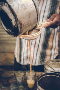 Midsection of man straining tea at market stall