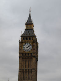 Low angle view of clock tower against cloudy sky