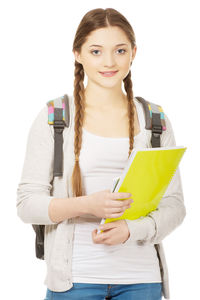 Portrait of smiling young woman standing against white background