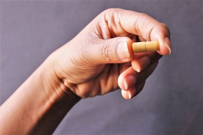 Close-up of hand holding cigarette