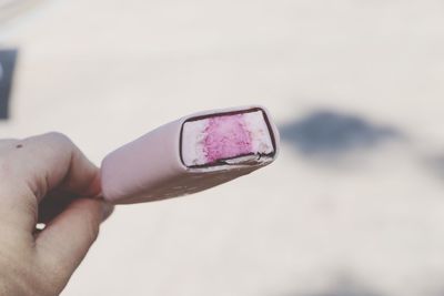 Close-up of hand holding eyeglasses against sky