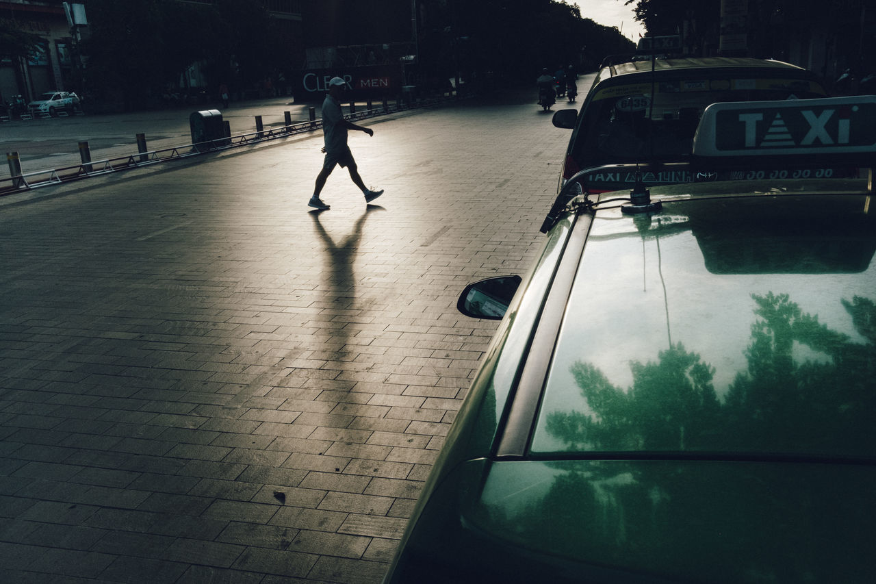 car, motor vehicle, mode of transportation, land vehicle, transportation, city, walking, real people, incidental people, street, nature, road, reflection, day, people, sunlight, outdoors, architecture, shadow