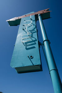 Low angle view of telephone pole against clear blue sky