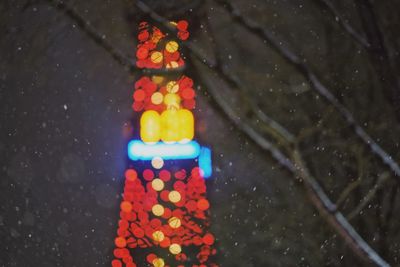 Close-up of illuminated lighting equipment on road at night