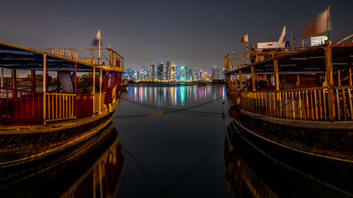 Panoramic view of illuminated buildings by river at night