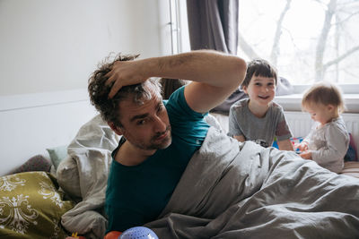 Mature man waking up surrounded with children