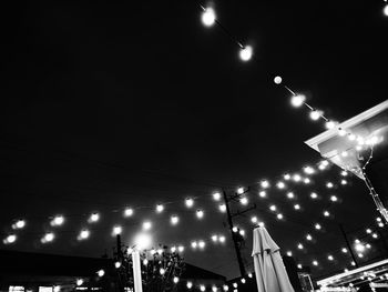 Low angle view of illuminated street lights against sky at night
