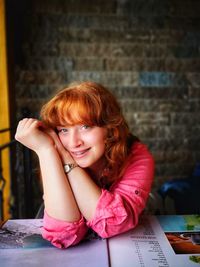 Portrait of a smiling young woman sitting on table